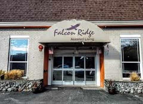 Front entrance of Falcon Ridge Assisted Living with glass doors and a decorative canopy.
