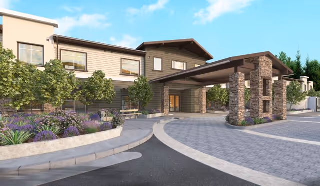 Exterior view of Peninsula Pointe by Cogir with a stone front entrance canopy and landscaped driveway.