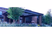 Exterior view of Centre Crest building entrance with steps, railing, and landscaped surroundings.