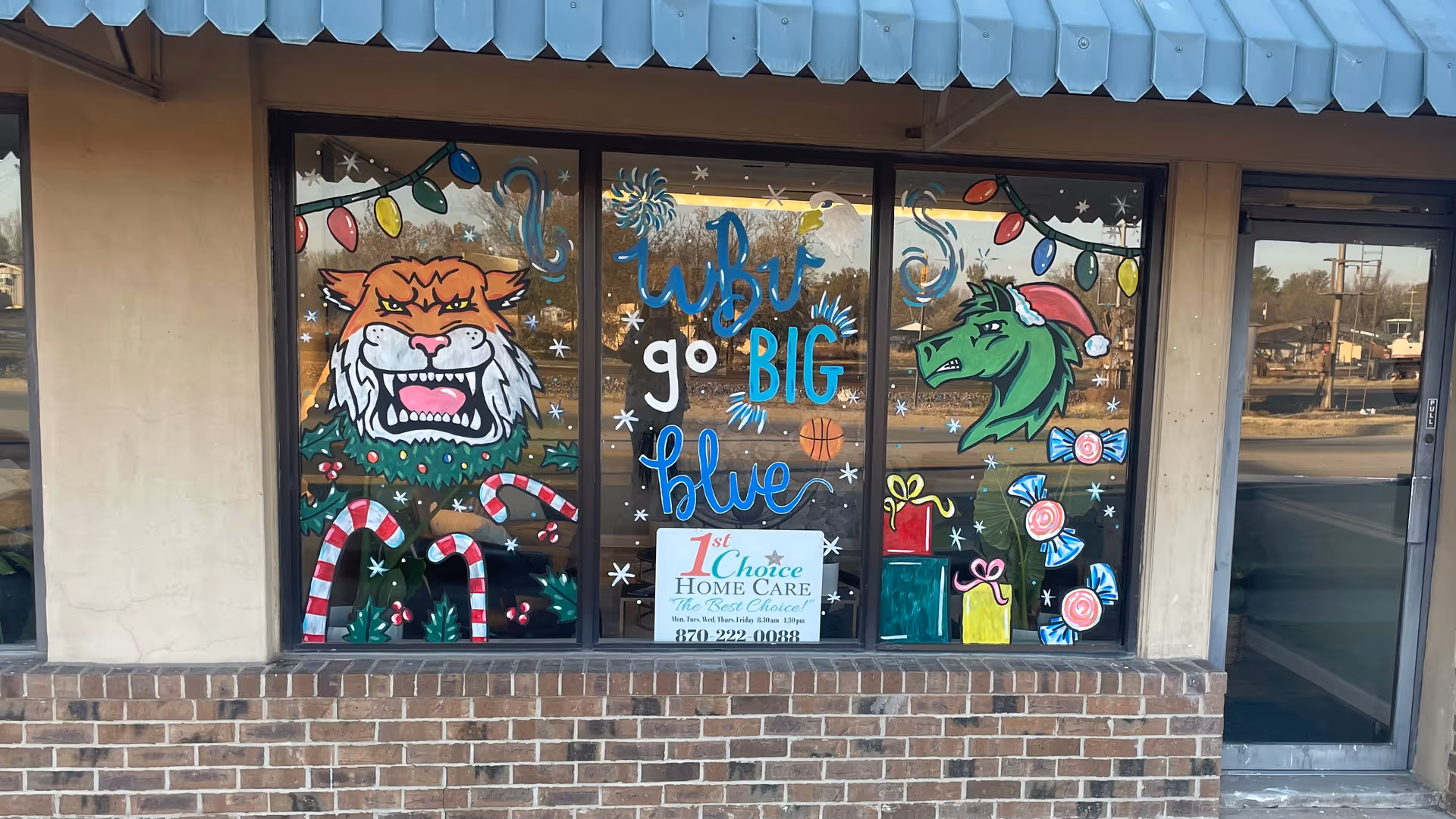 Colorful storefront windows decorated with holiday artwork and the 1st Choice Home Care sign.