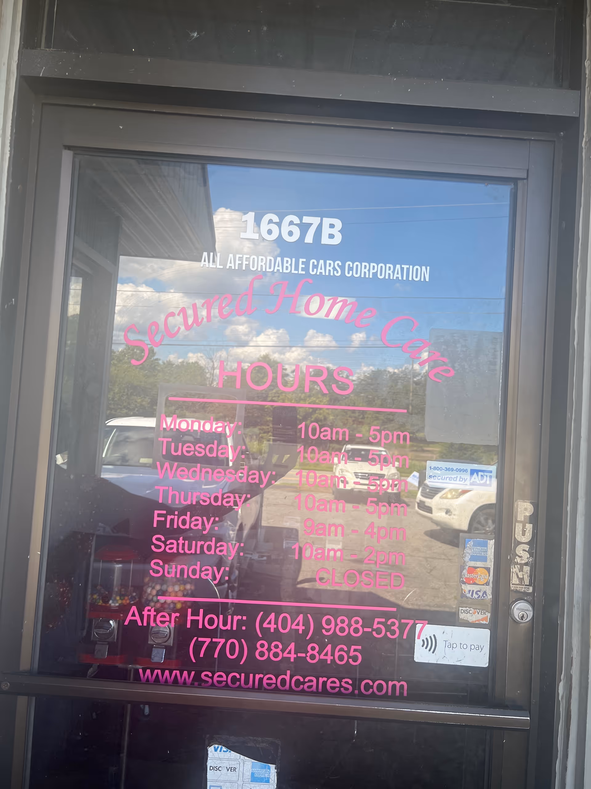 Glass storefront door with pink 'Secured Home Care' hours and contact information.