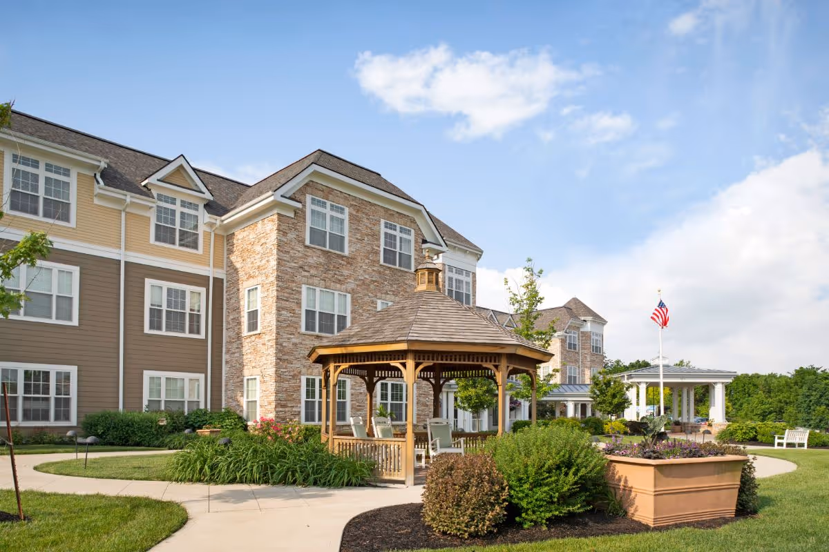 Exterior view of the Sunrise of Dublin building with a wooden gazebo, landscaped grounds, and an American flag.