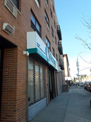 Brick building on a city sidewalk with a blue Regency Health Care sign and storefront.