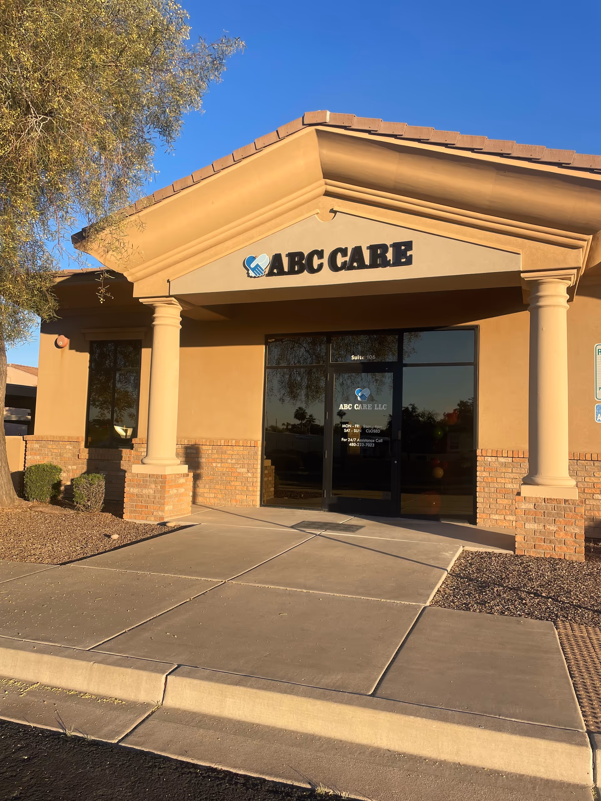Senior living facility entrance with tan façade, columns, and ABC CARE signage.