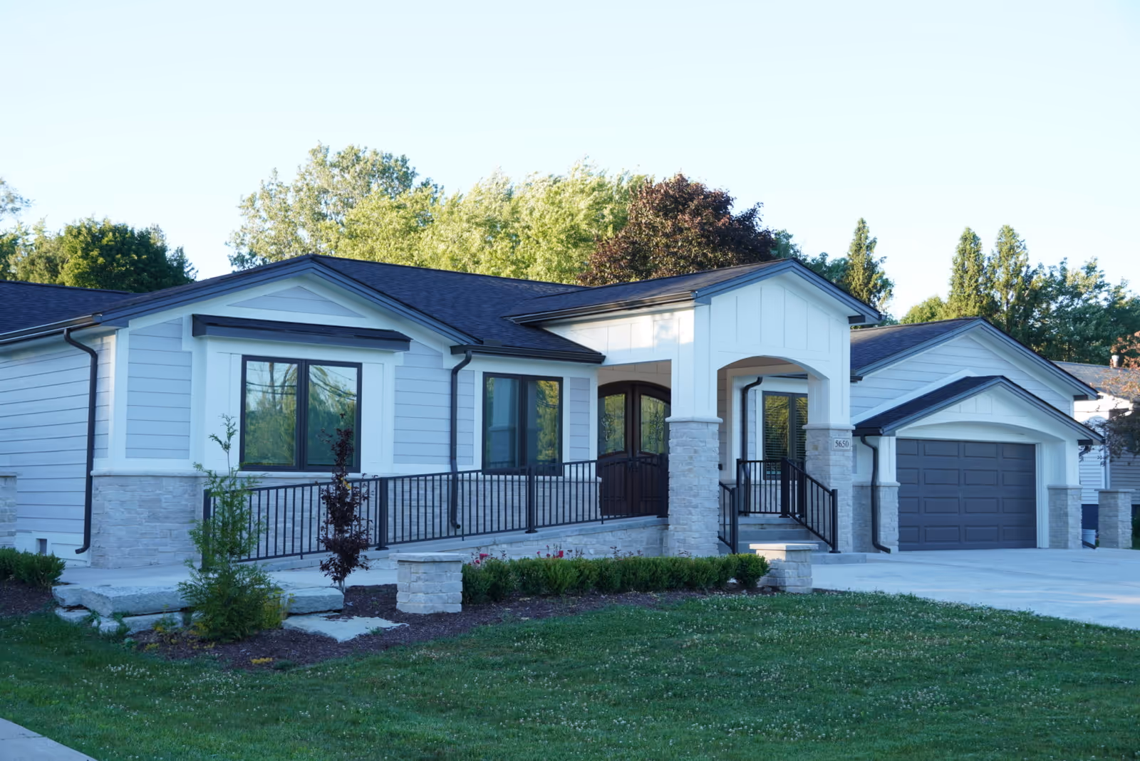 Single-story senior living facility exterior with a covered front entry and attached garage.