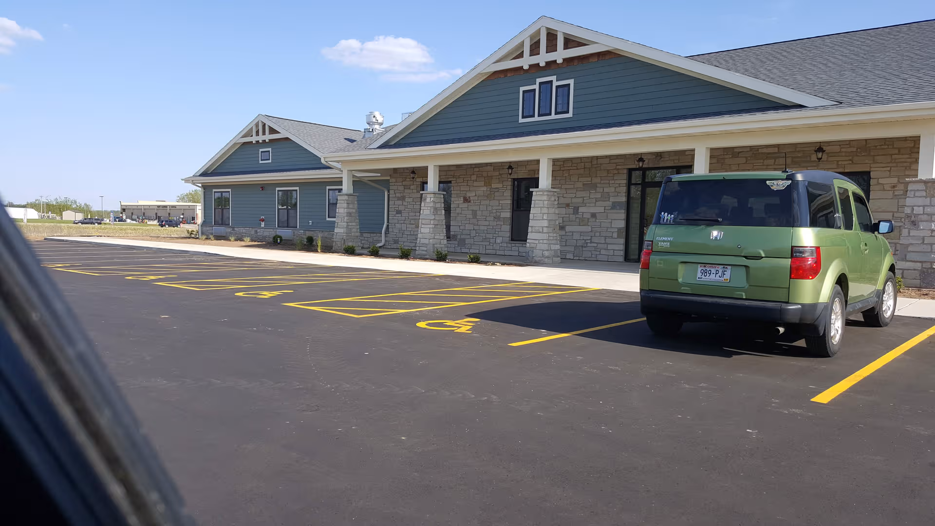 Exterior view of Country Villa Assisted Living building with a green SUV in parking lot