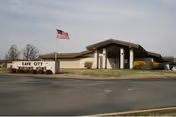 Exterior view of Cave City Nursing Home with a flag and front entrance.
