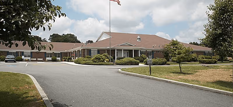 Exterior view of Hillsville Health and Rehab Center with a curved driveway and landscaping.