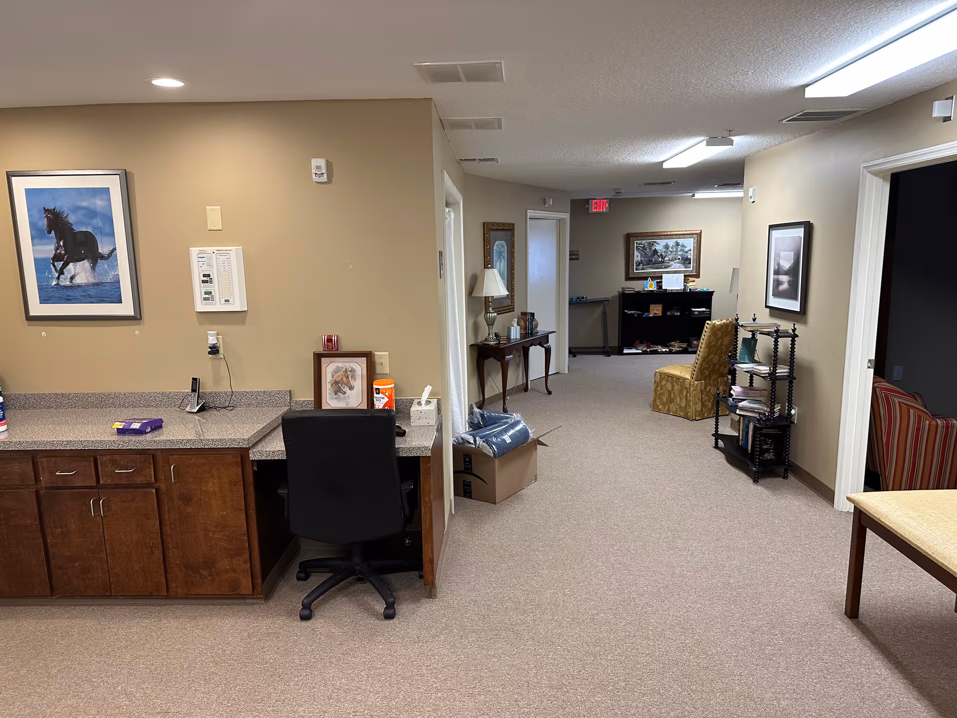 Interior of Care Oasis Caregivers facility: hallway with desk and lounge seating.