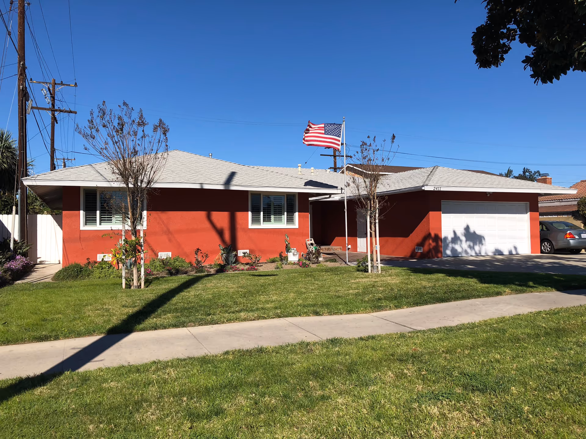Single-story red facility with white garage, flag, and front lawn.