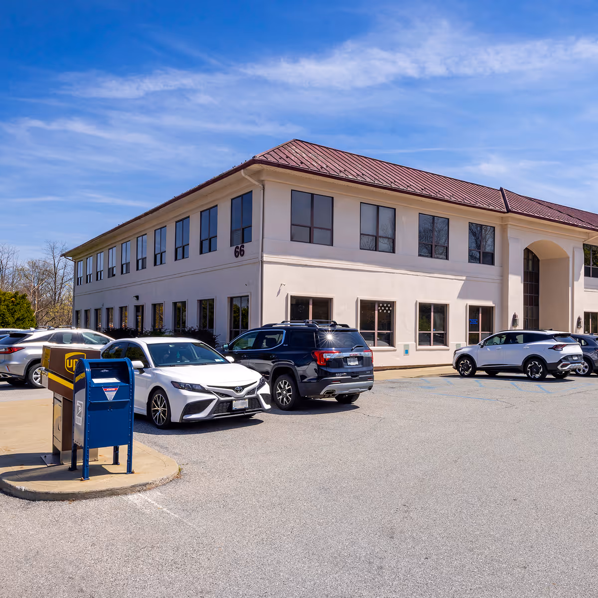 Exterior of a two-story white medical building with a parking lot.