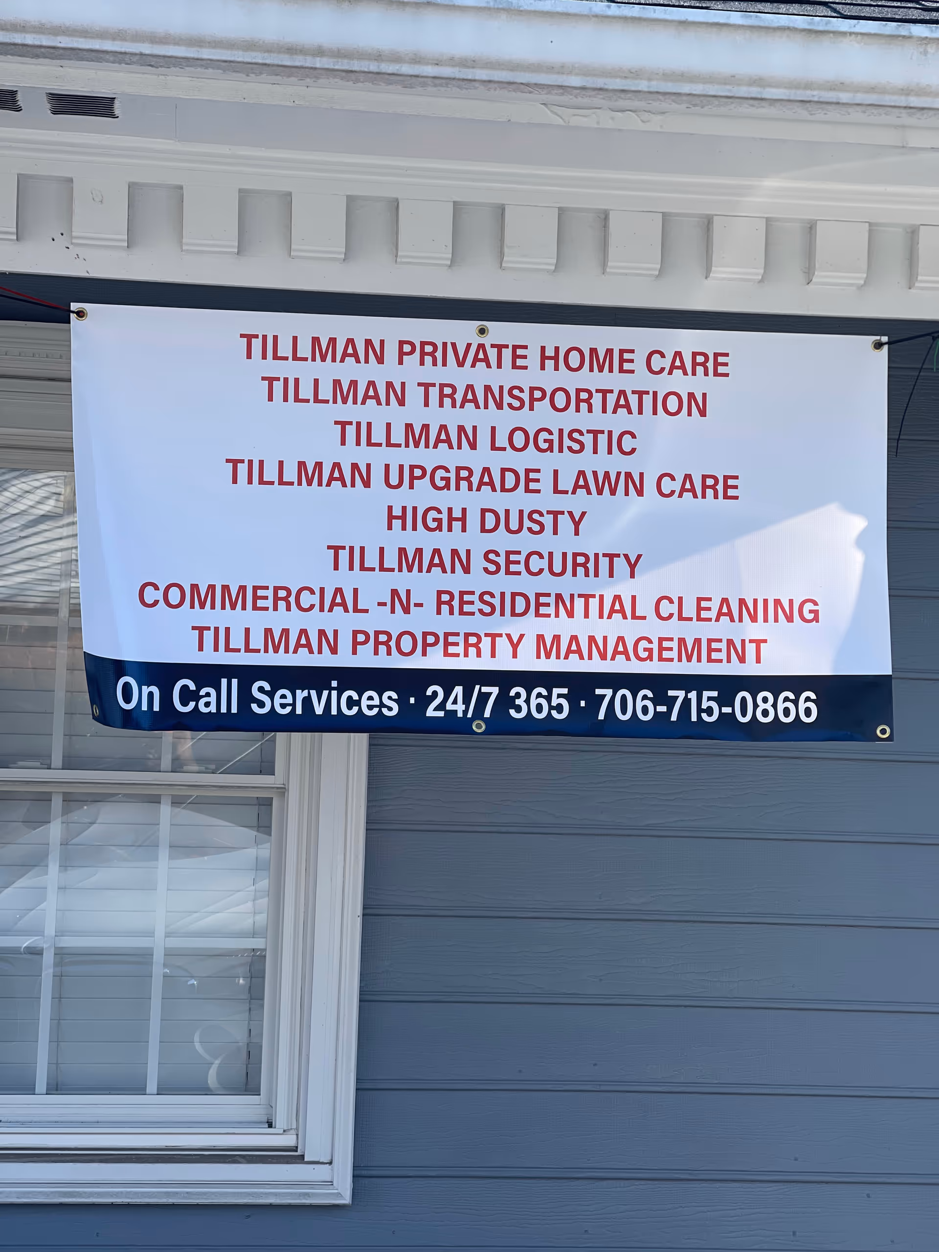 Exterior building with a large banner listing Tillman services and contact information.