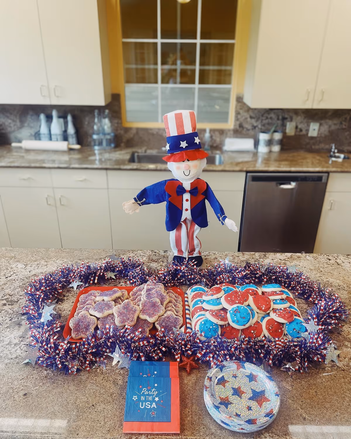 Patriotic Uncle Sam figure on a kitchen counter with red, white, blue cookies