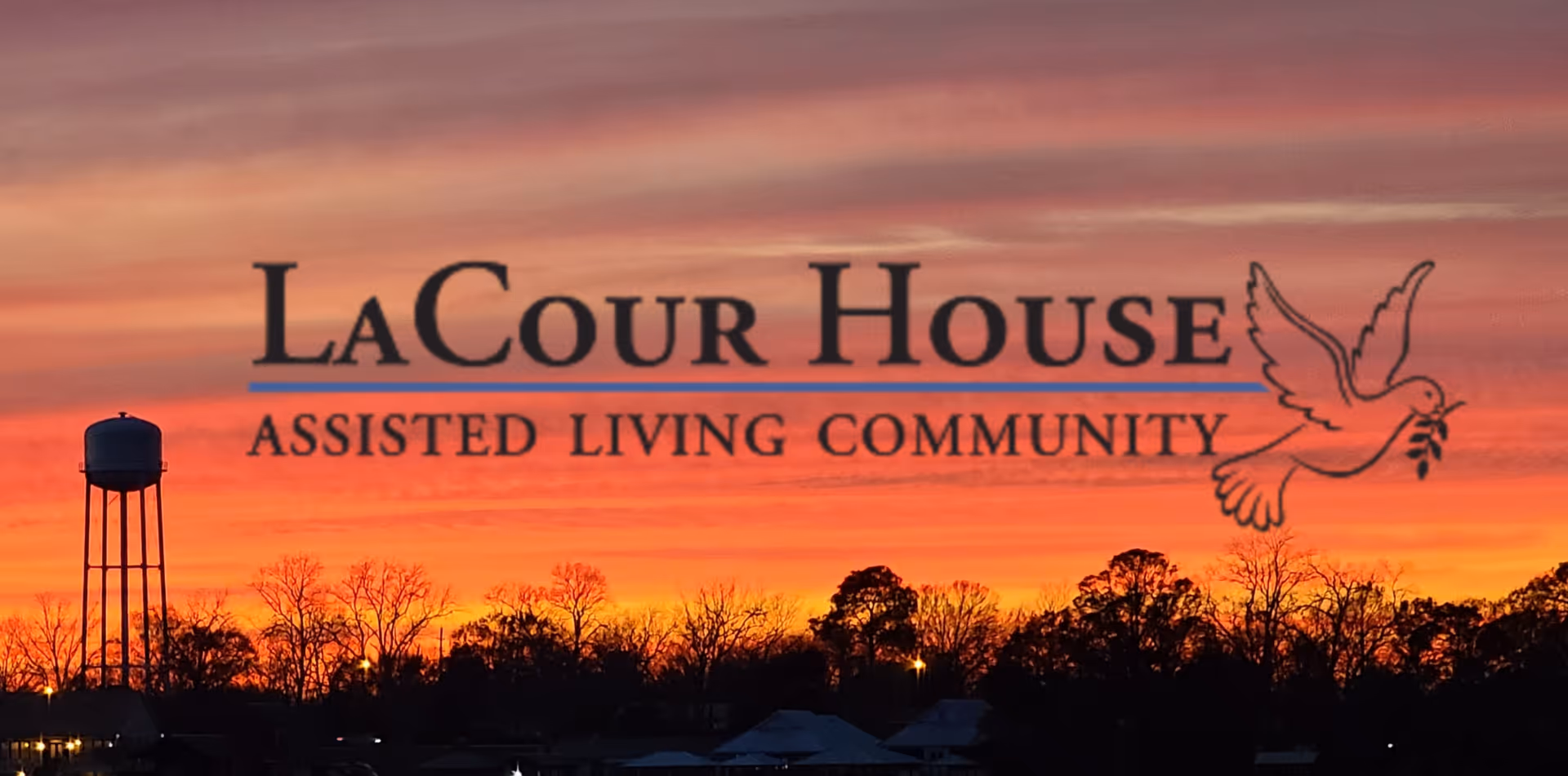 LaCour House Assisted Living Community sign silhouetted against sunset with trees and a water tower