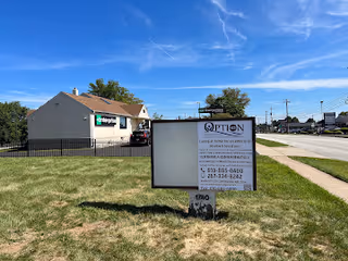 Exterior view of Option Companion Care building with sign on grassy front yard