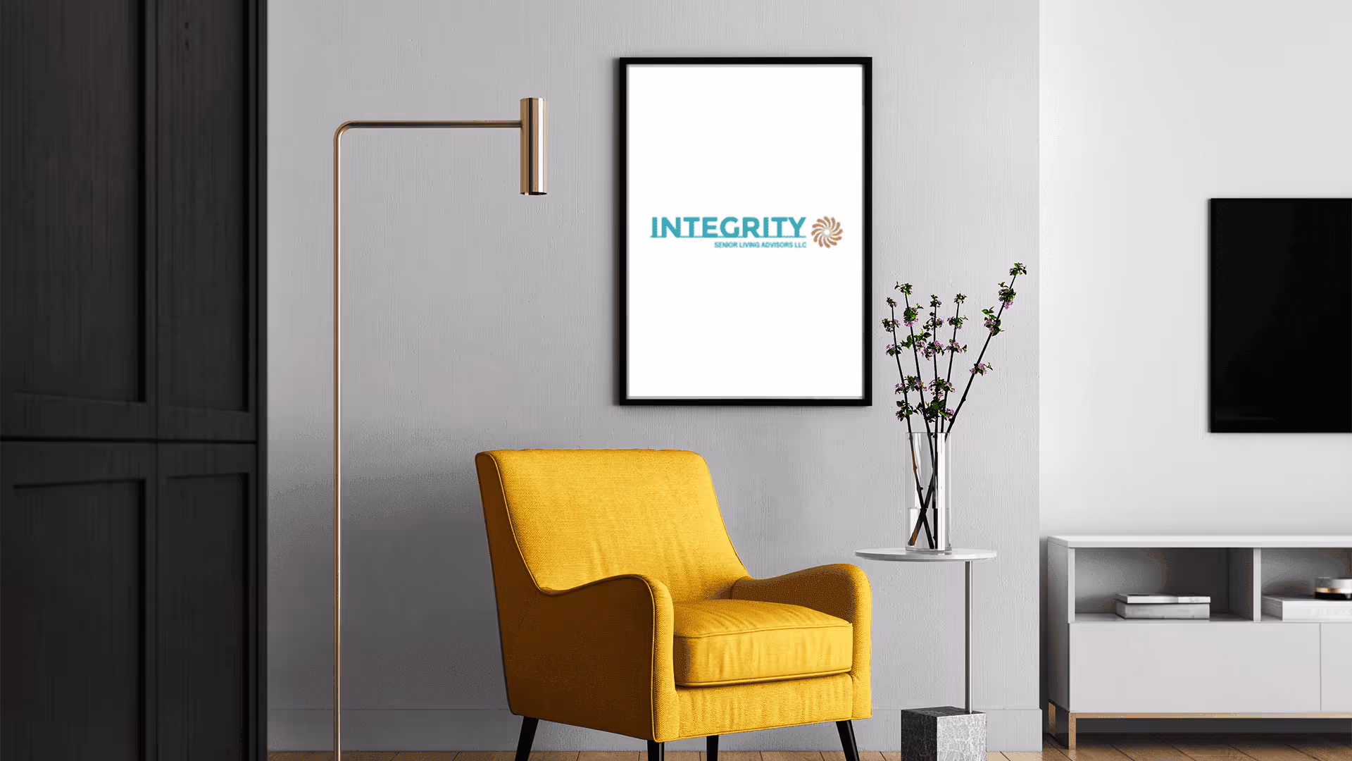Bright yellow armchair with a modern floor lamp and framed Integrity logo in a living room.