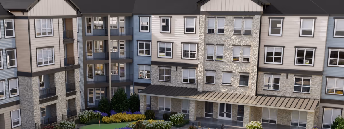Front view of a multi-story senior living building with balconies and a landscaped courtyard.