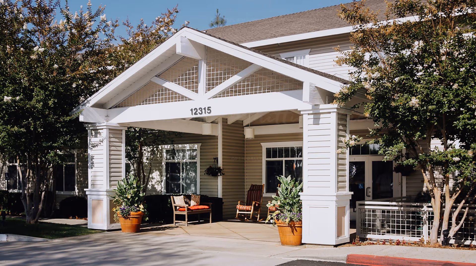 Exterior view of Discovery Commons Whittier entrance with a white porch and seating.
