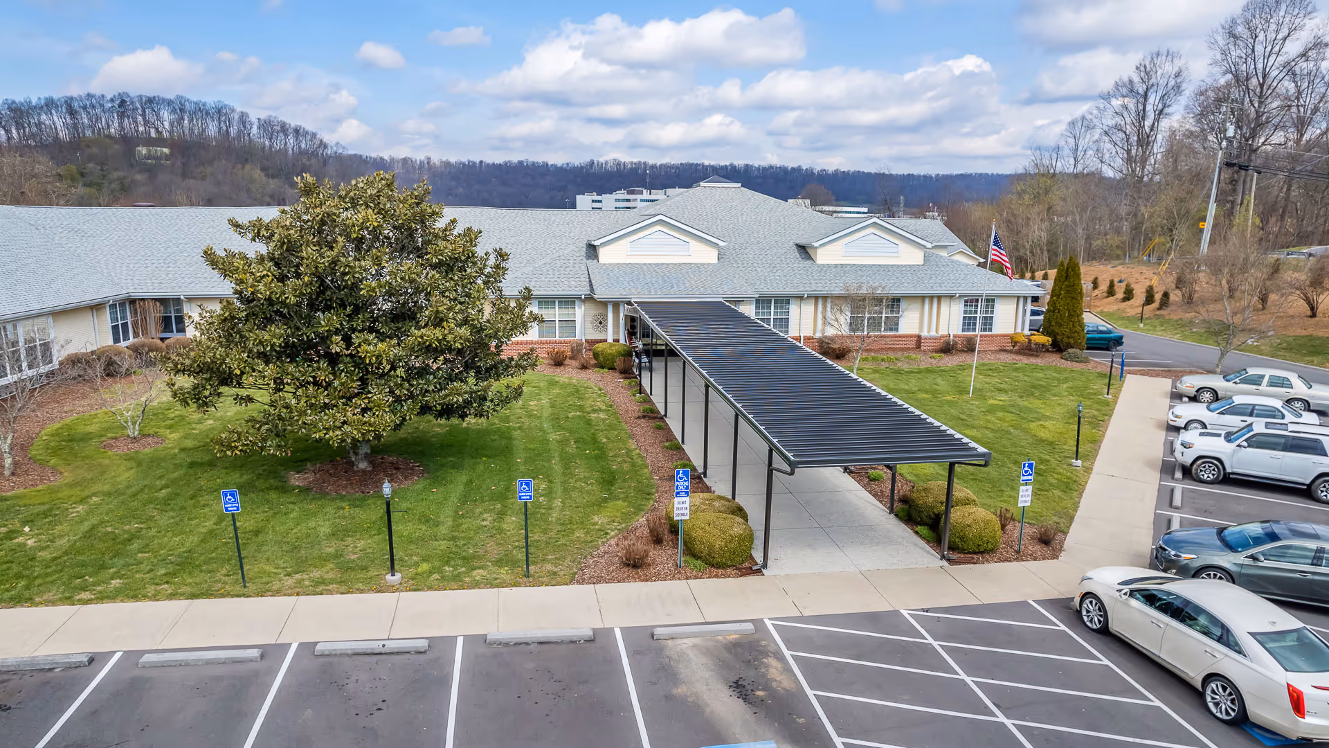 Exterior view of American House Bristol with a covered entrance and parking lot.