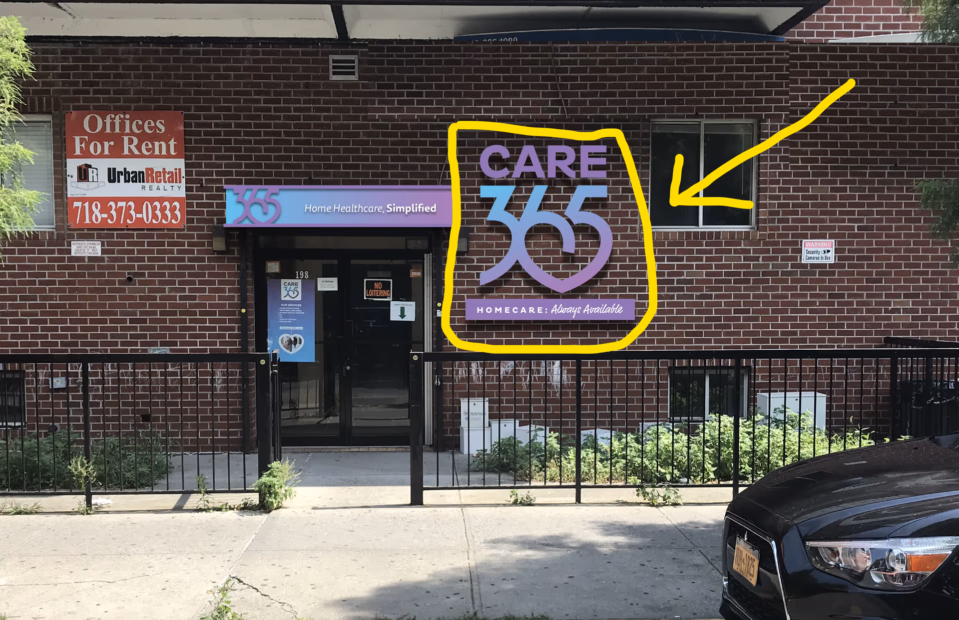 Brick building exterior featuring Care365 sign, storefront entrance, and parked car in foreground.