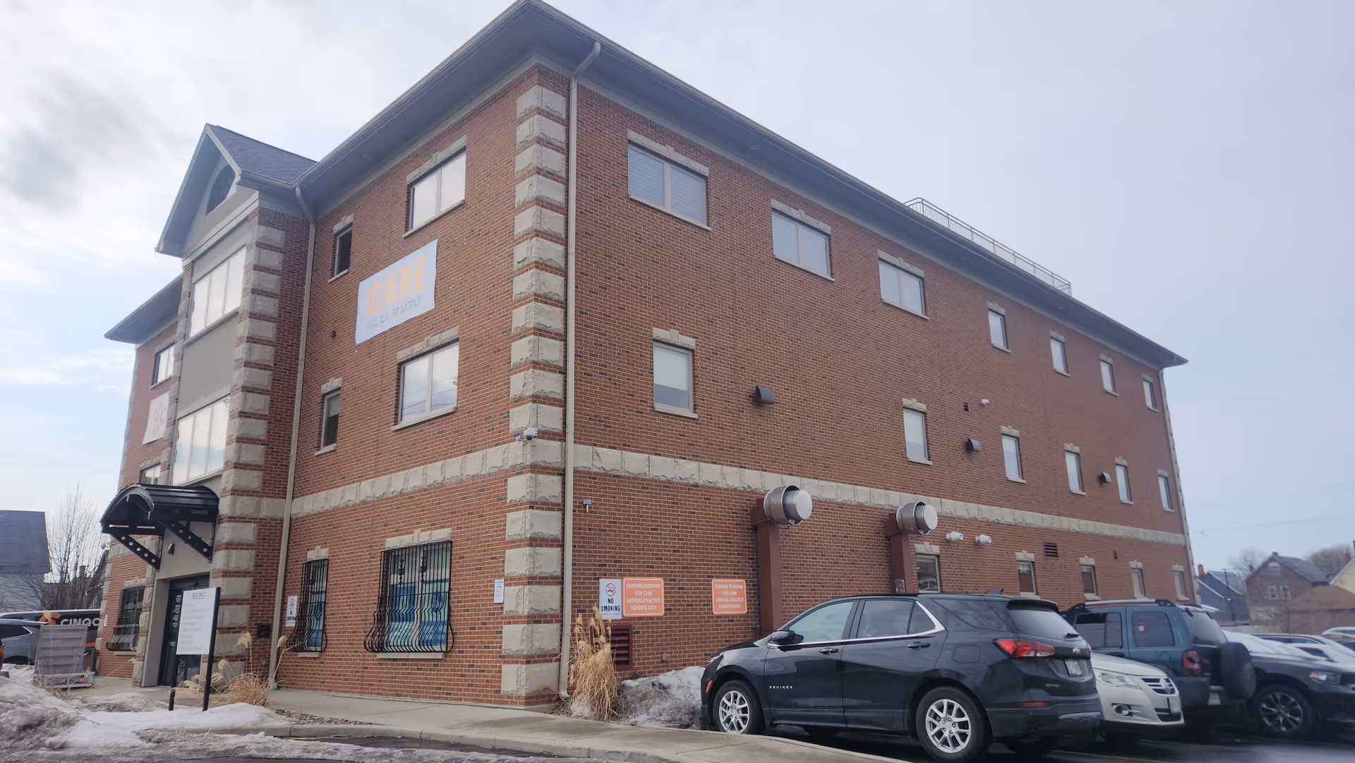 Brick senior living building with parked cars and CINQCARE sign on Niagara Street