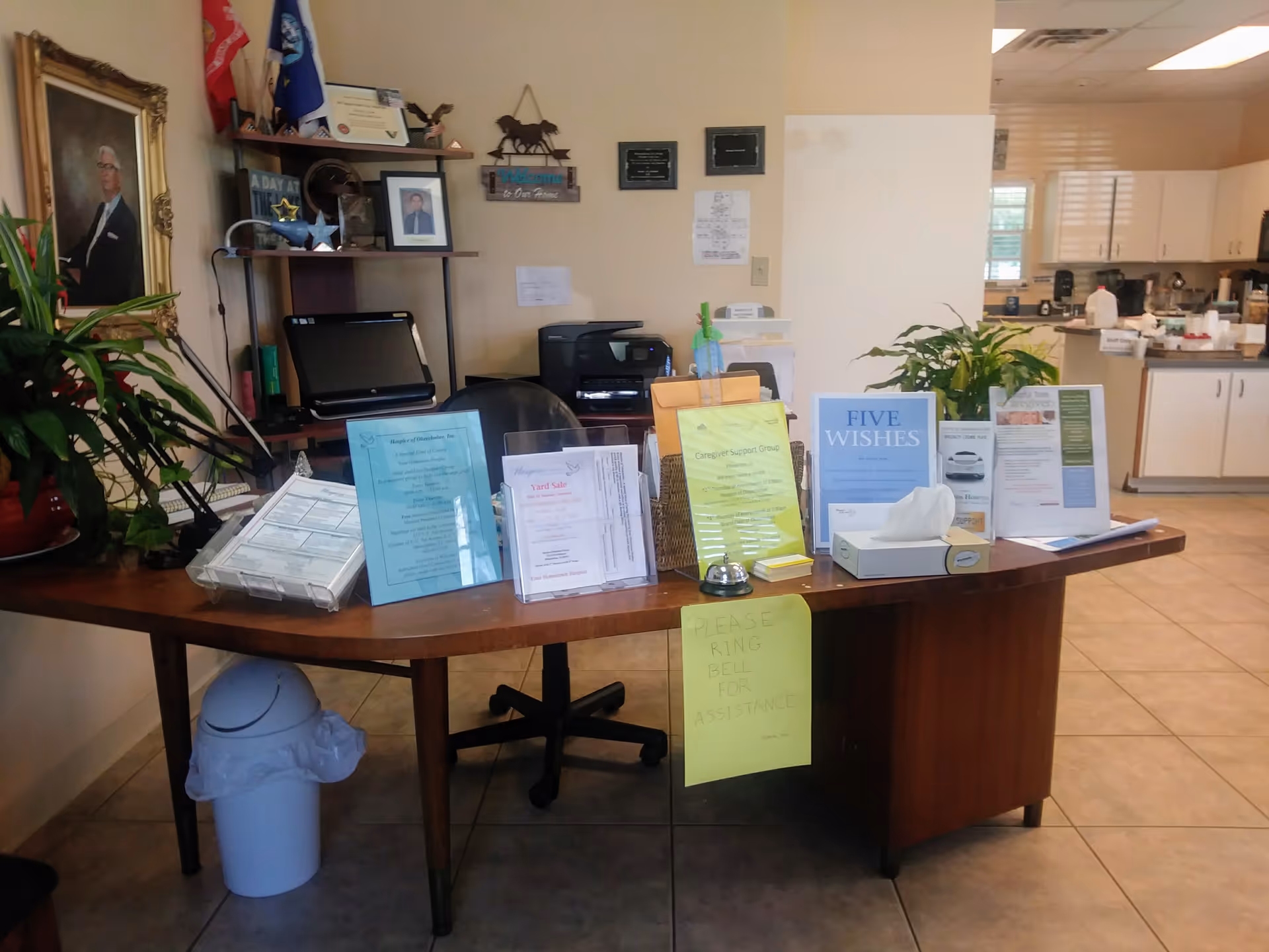 Reception desk with brochures and office supplies inside a senior facility lobby.