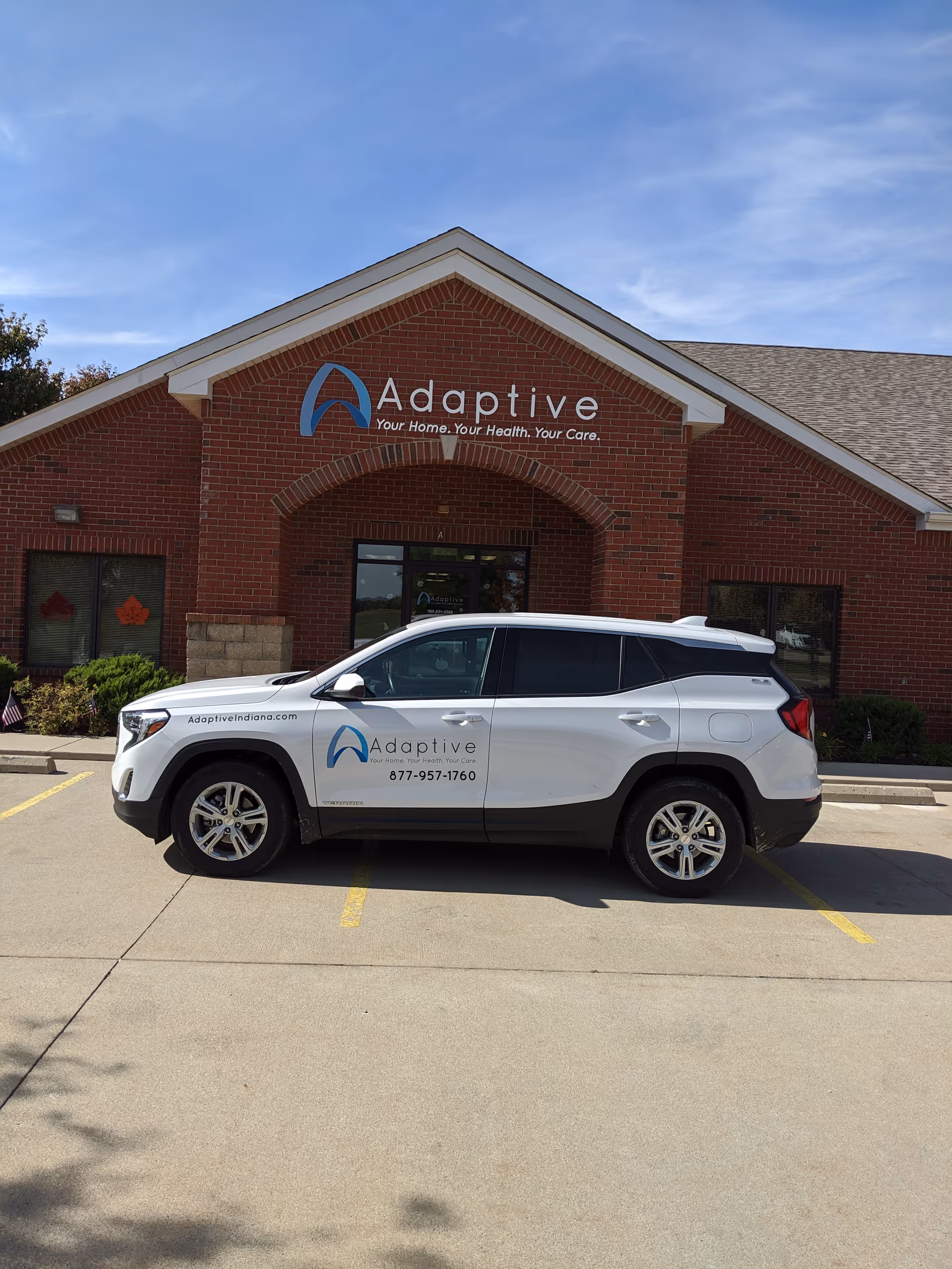 Brick Adaptive Nursing building with a white service vehicle parked in front.