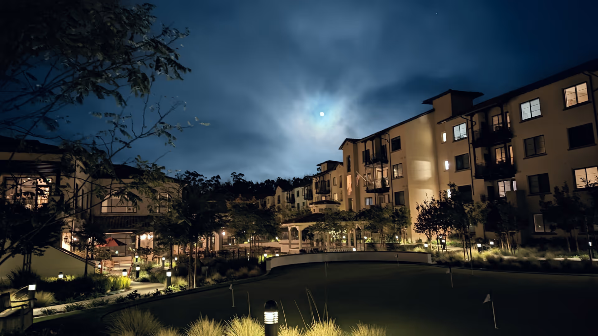 Nighttime exterior view of The Glen at Scripps Ranch courtyard and apartment buildings.