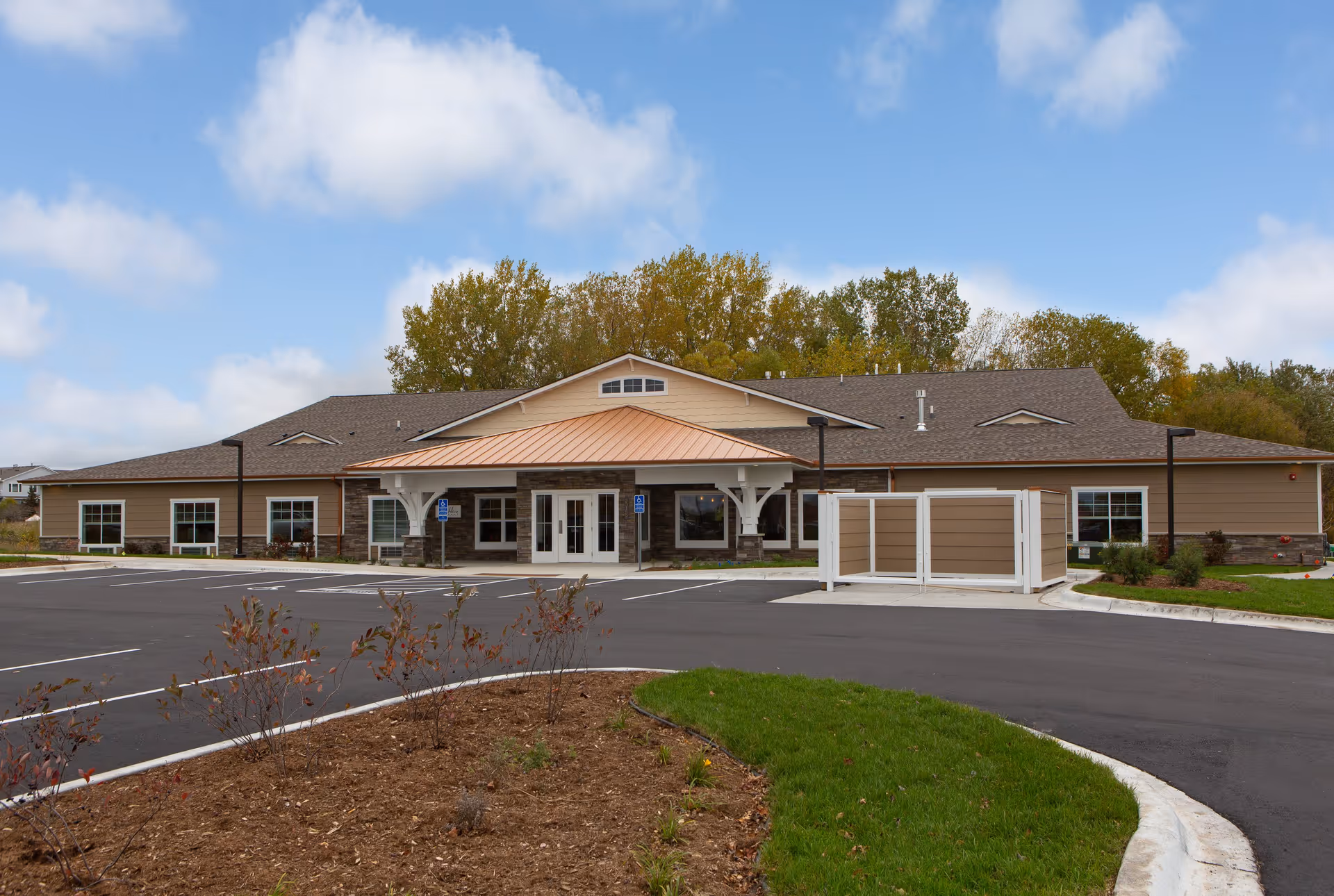 Single-story Beehive Homes of Lakeville exterior with parking lot and landscaped entrance.