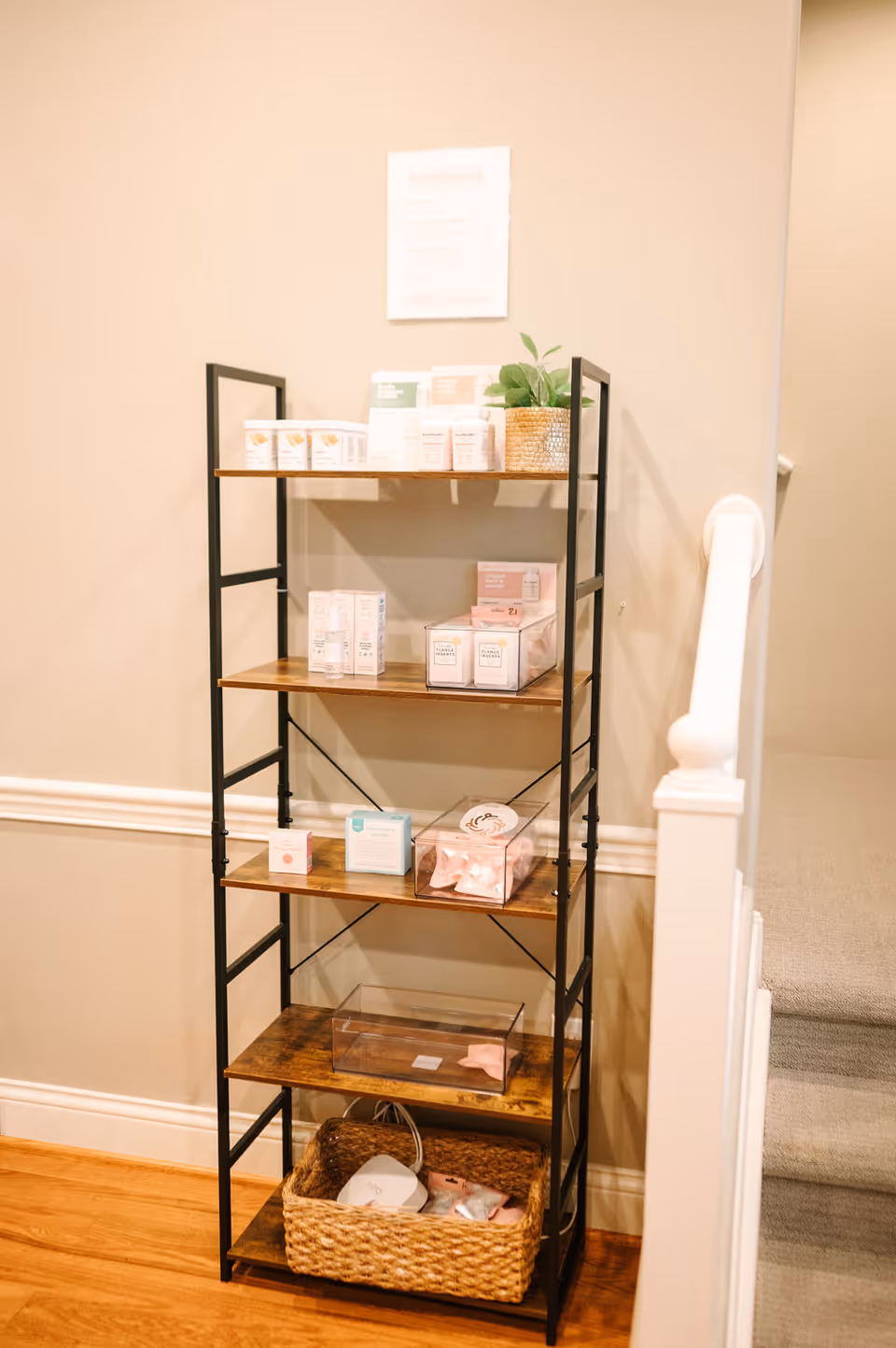 Tall metal-framed shelf with assorted boxed products and a woven basket.