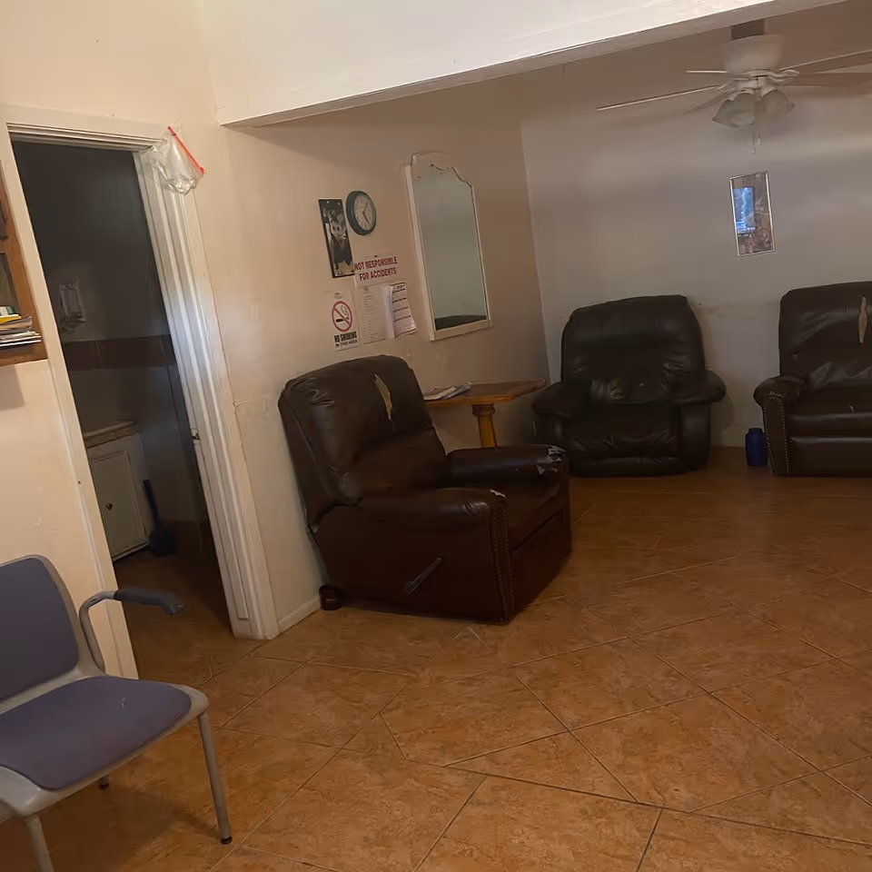 Cozy senior living lounge with brown recliners, a small table, and wall decor.
