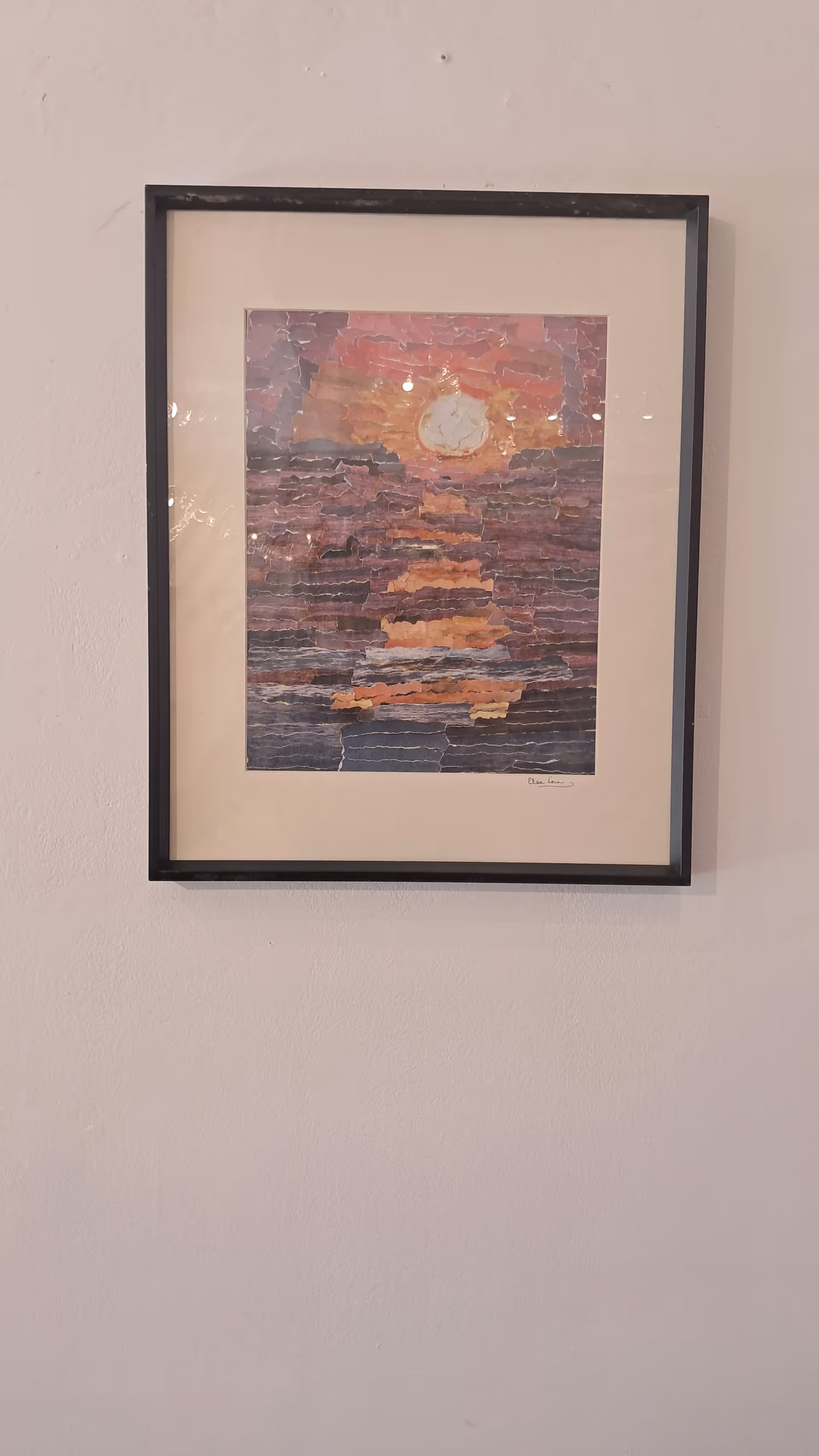 Framed abstract painting hangs on a light wall in a facility hallway.