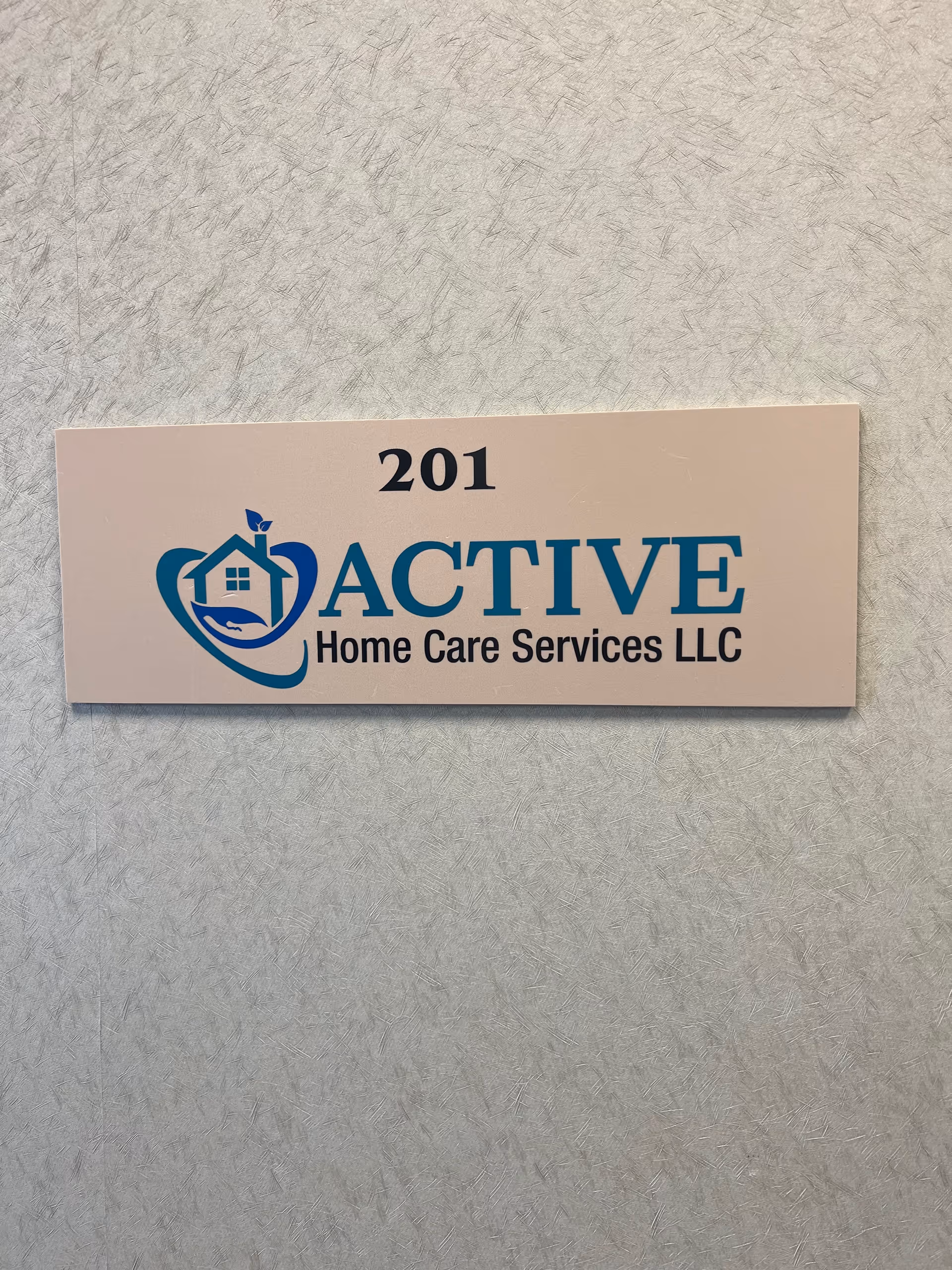 Sign reading 201 Active Home Care Services LLC on a textured interior wall.