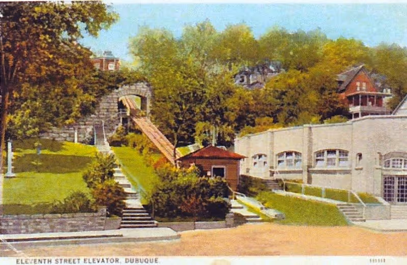 Exterior view of a pastel building with stairs, a slide, and landscaped grounds.