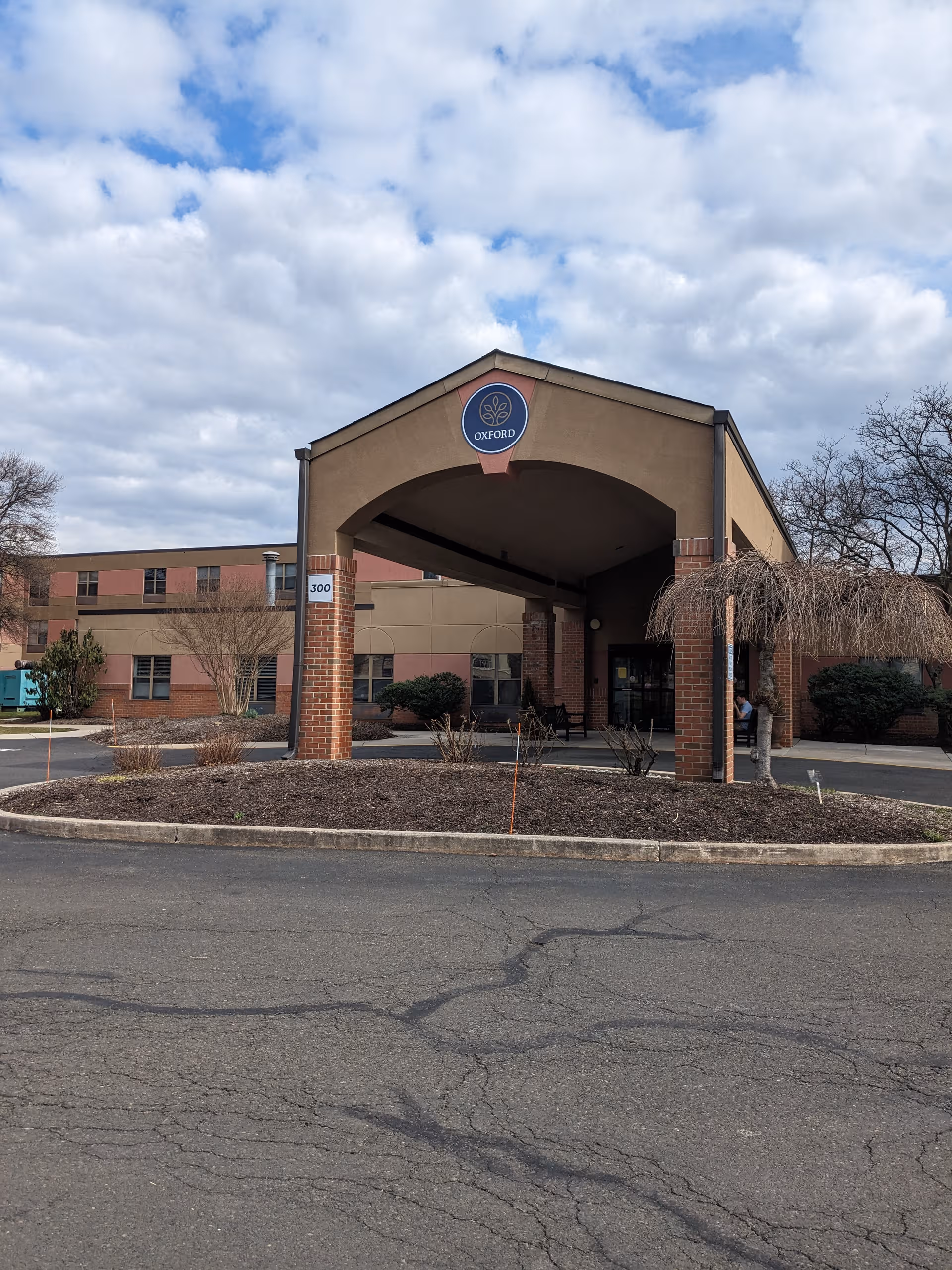 Exterior view of Oxford Rehabilitation & Healthcare Center entrance with brick arches and parking lot.
