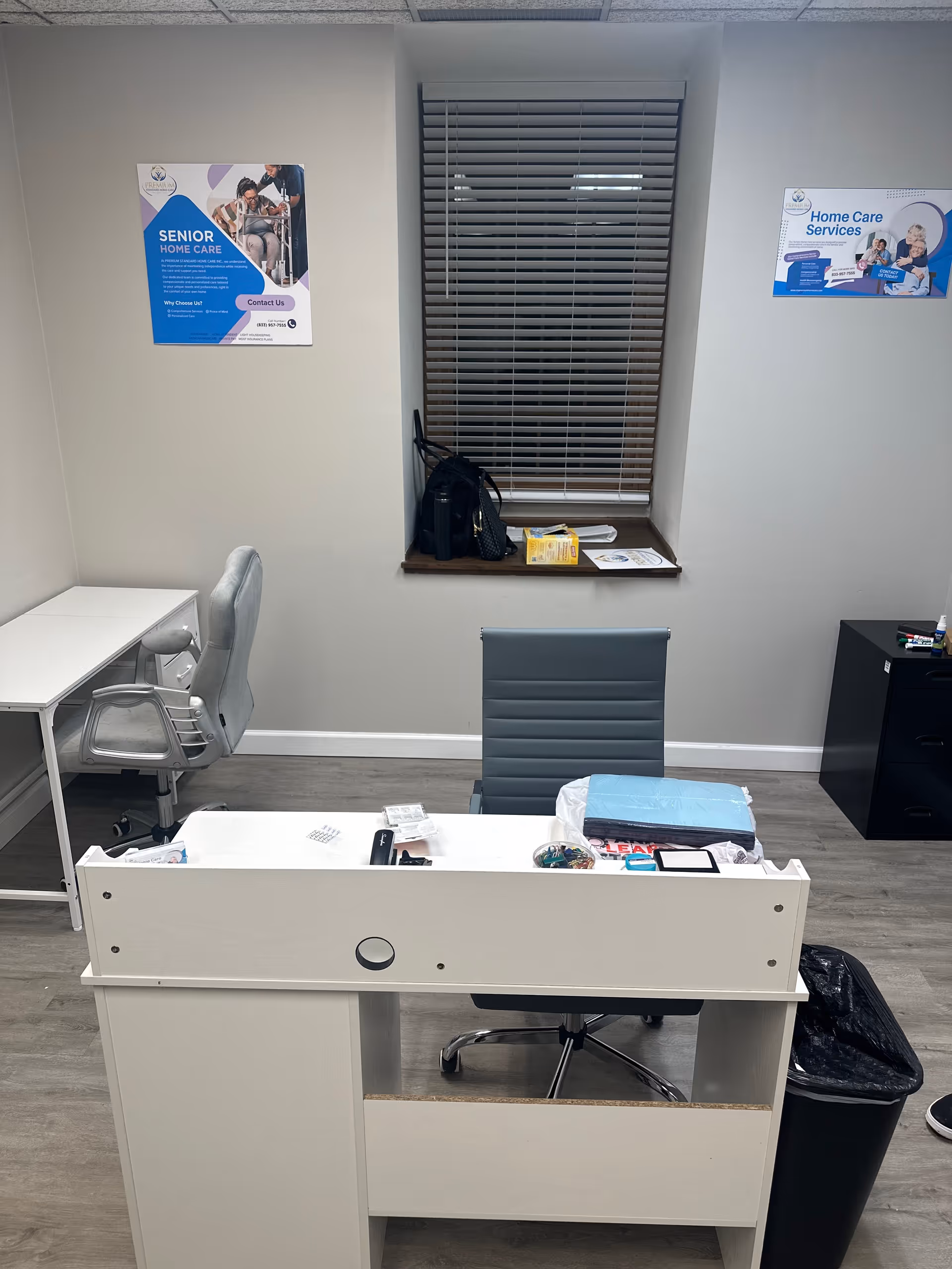 Empty reception desk in a small interior office with blinds and senior care posters