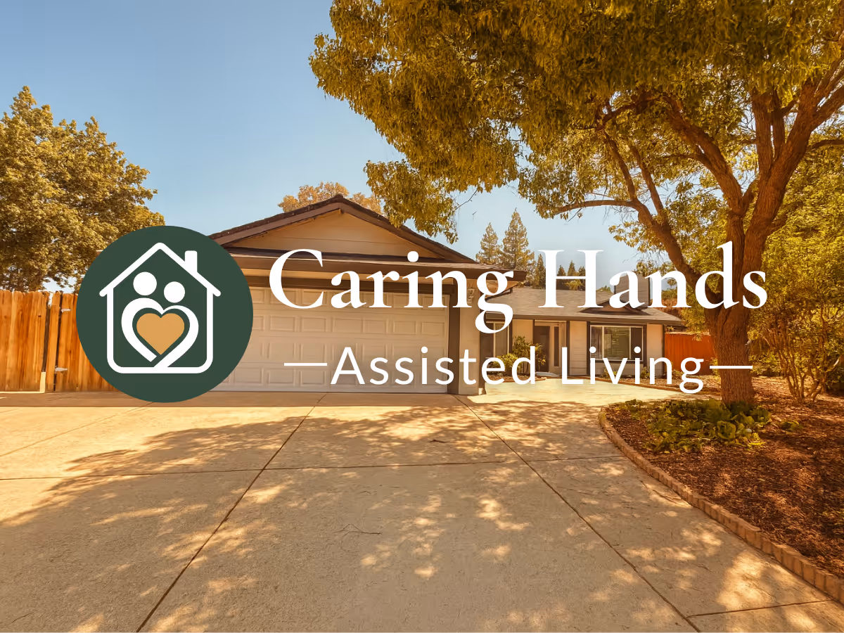 Exterior view of Caring Hands Assisted Living facility with driveway and trees.