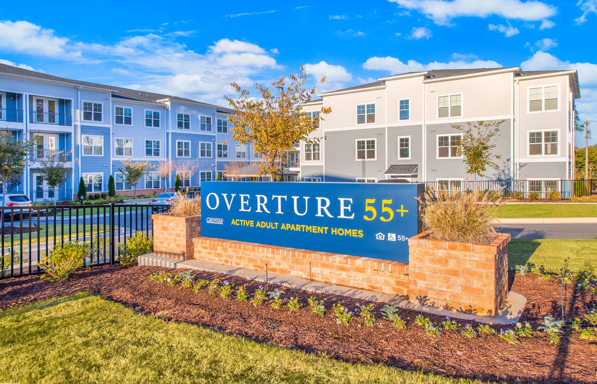 Exterior view of Overture Centennial senior living campus with a blue sign.