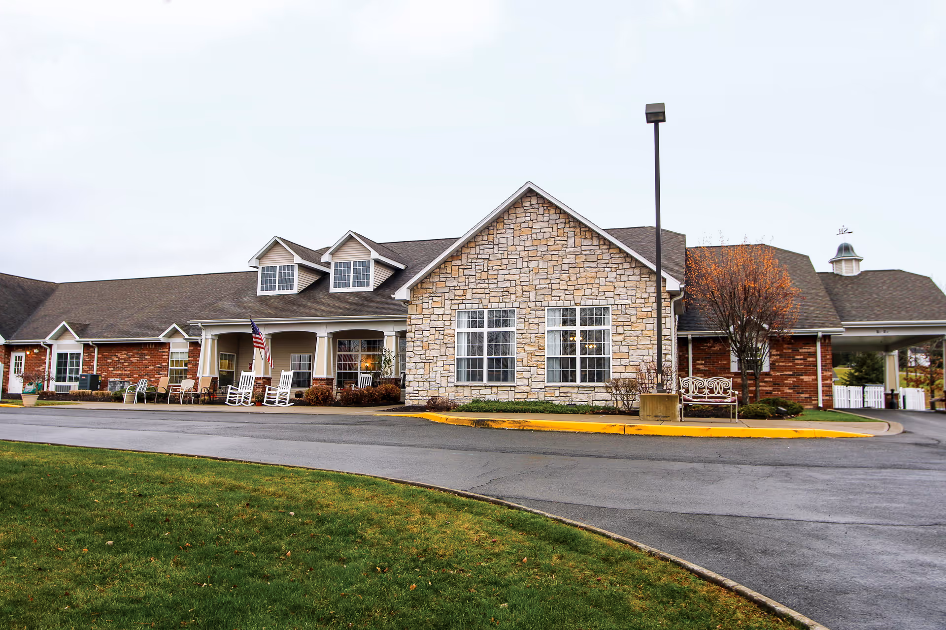 Exterior view of a senior living facility with stone facade and welcoming entrance.