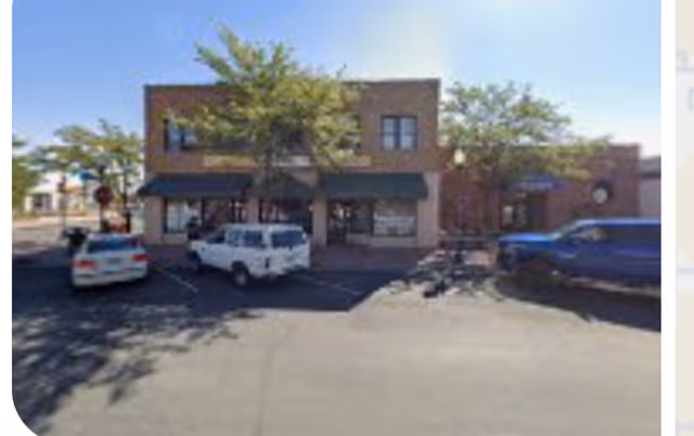 Brick Yellowstone Homecare storefront with black awnings and parked cars in front.