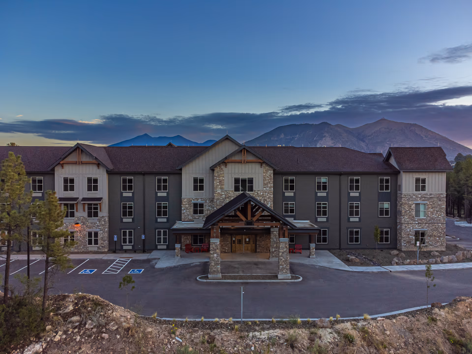 Front view of a senior living building with stone accents and a covered entrance.