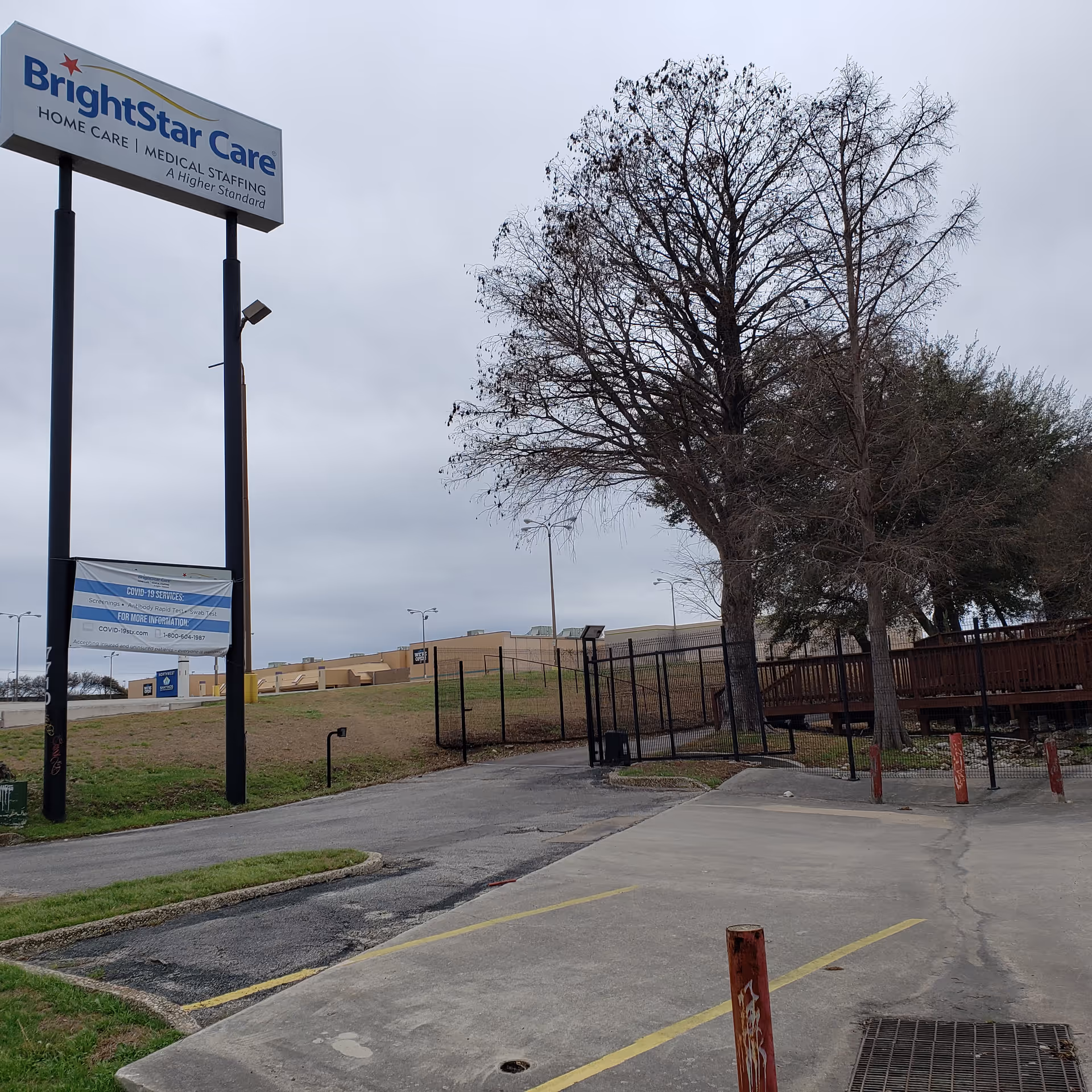 BrightStar Care sign and entrance area with trees and a fence outside the testing site.