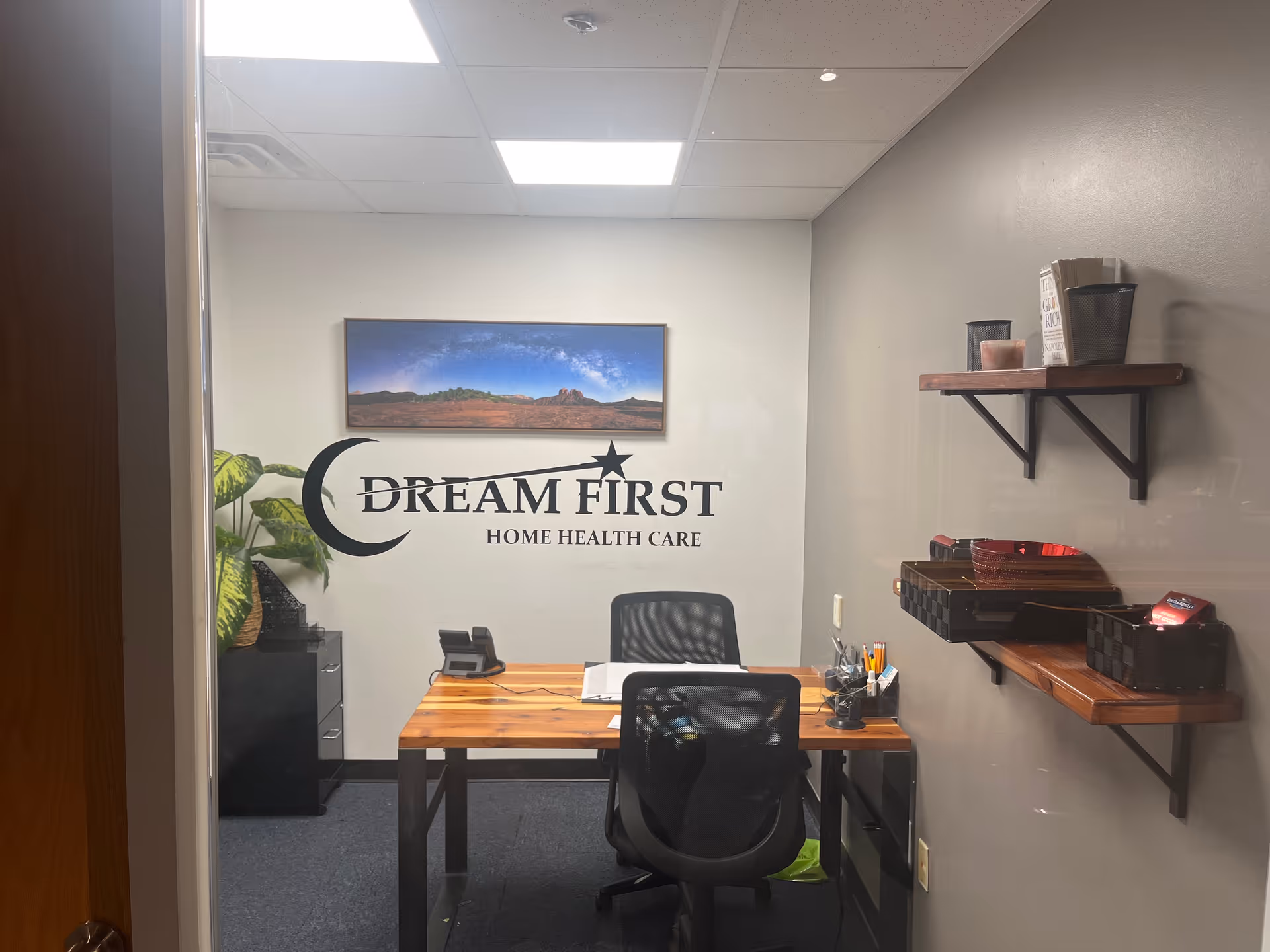 Reception area of Dream First Home Health Care with desk, chair, and wall logo.