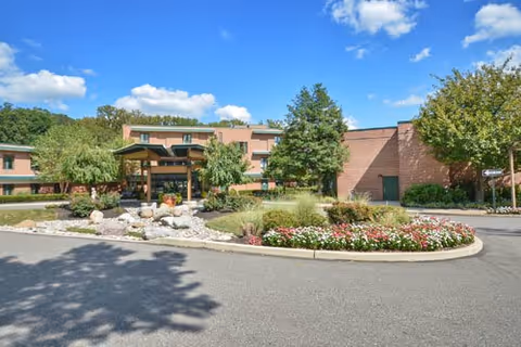 Front exterior of Wesley Enhanced Living at Pennypack Park with circular driveway and landscaping.