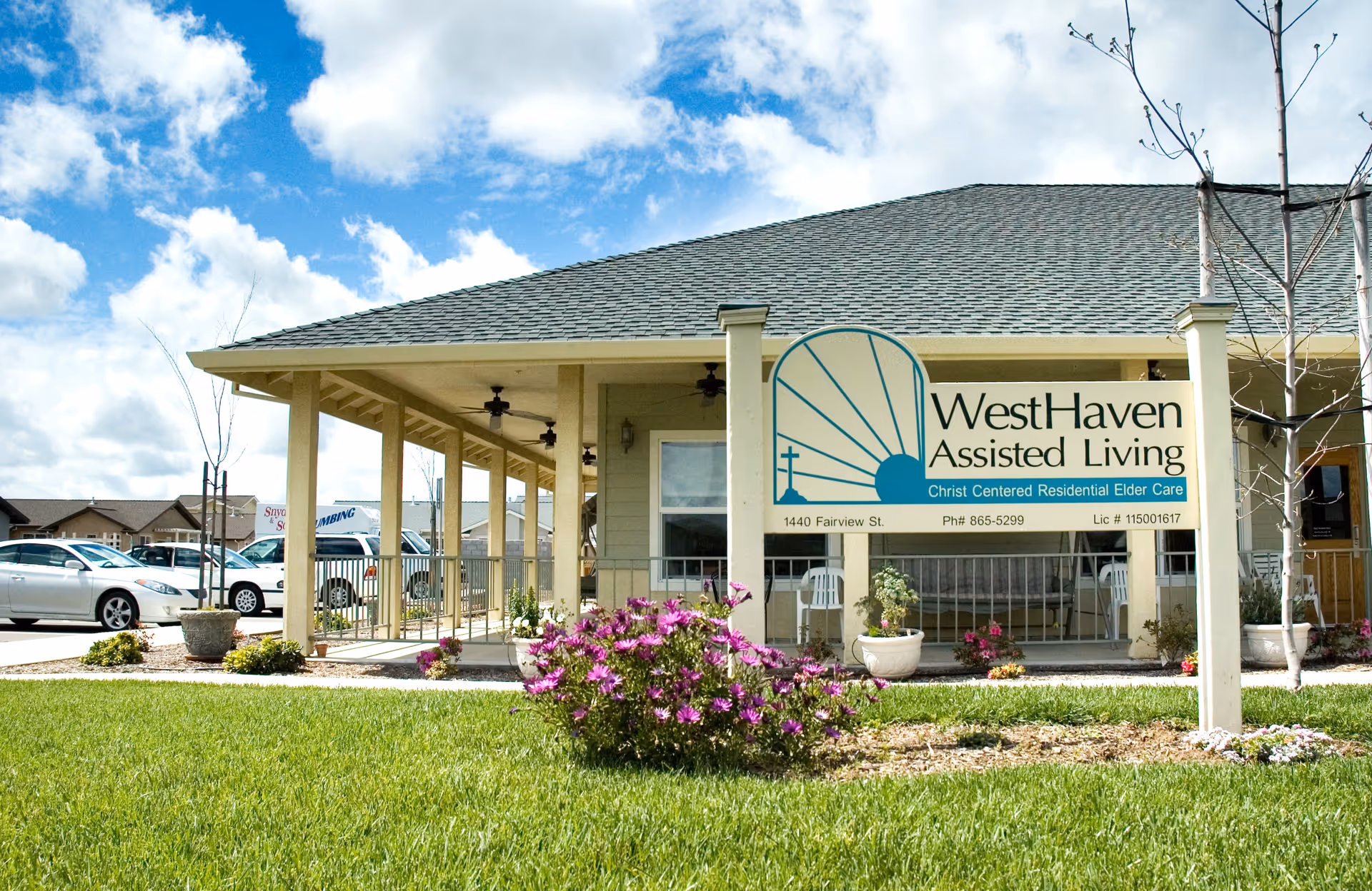 Front exterior of Westhaven Assisted Living with a covered entrance and flowering shrubs.
