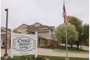 Exterior view of Evans Memorial Home with a sign and an American flag.