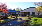 Single-story senior living facility front with walkway and landscaped entrance.