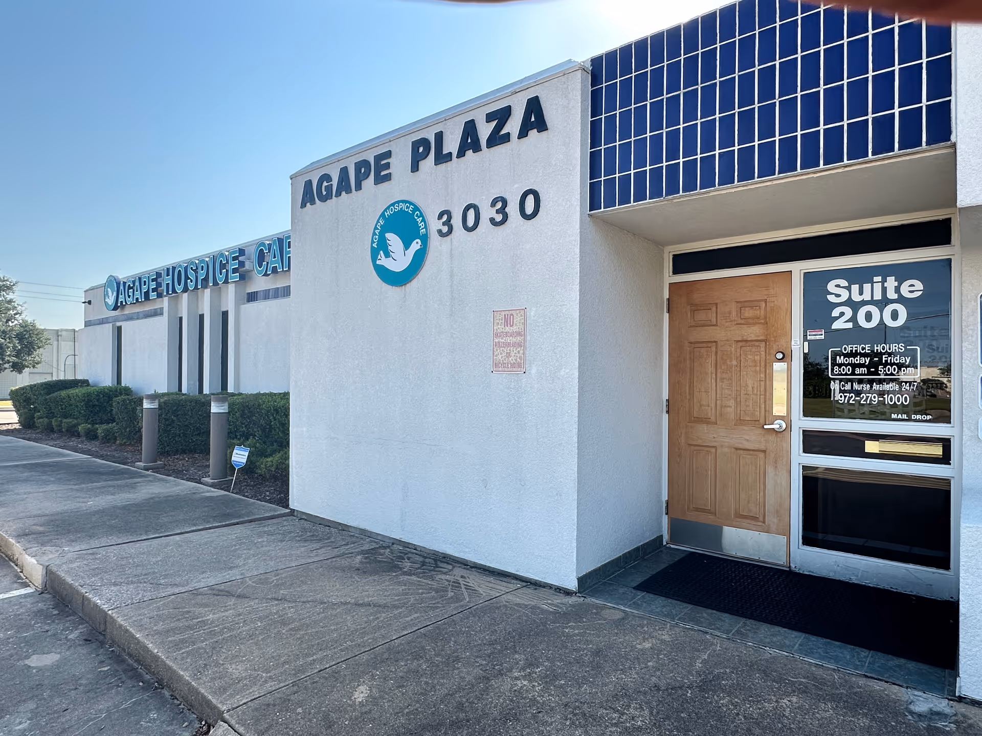 Exterior of Agape Hospice Care building with Agape Plaza signage and front entrance.