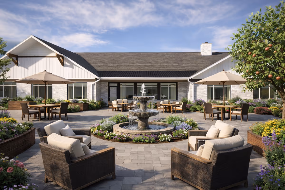 Outdoor terrace of Aspen Estates with fountain, cushioned seating, umbrellas, and landscaped planters.