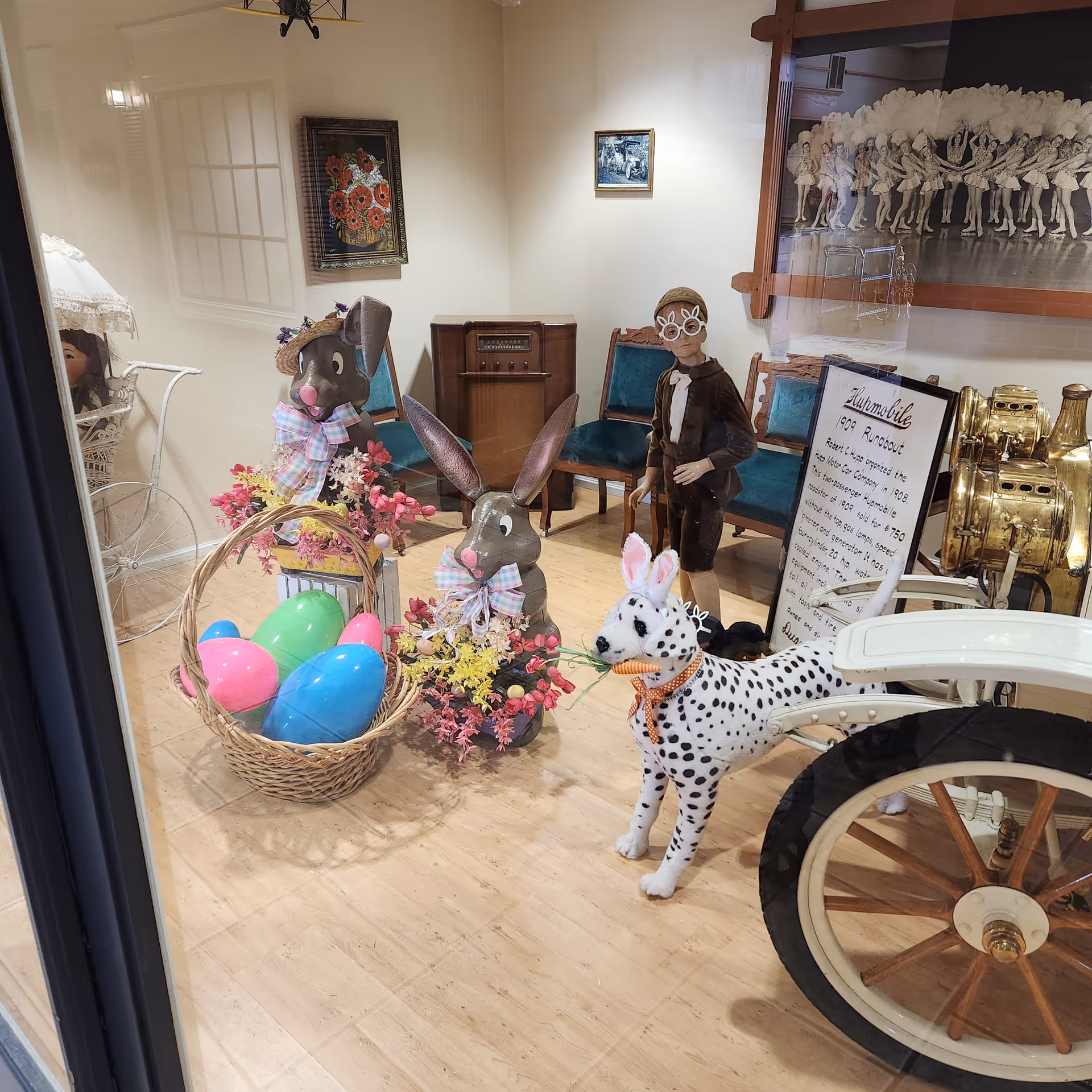 Easter-themed indoor display with toy rabbits, a dalmatian figure, and vintage furniture.